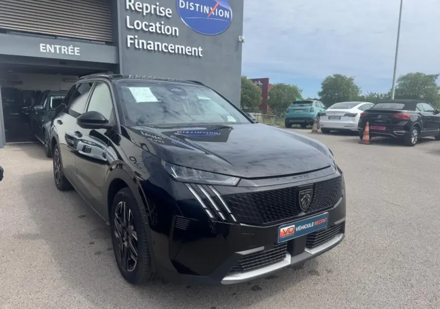 Peugeot 5008 Hybrid noir en 3/4 avant droit, avec jantes alliage 19 pouces et barres de toit visibles.