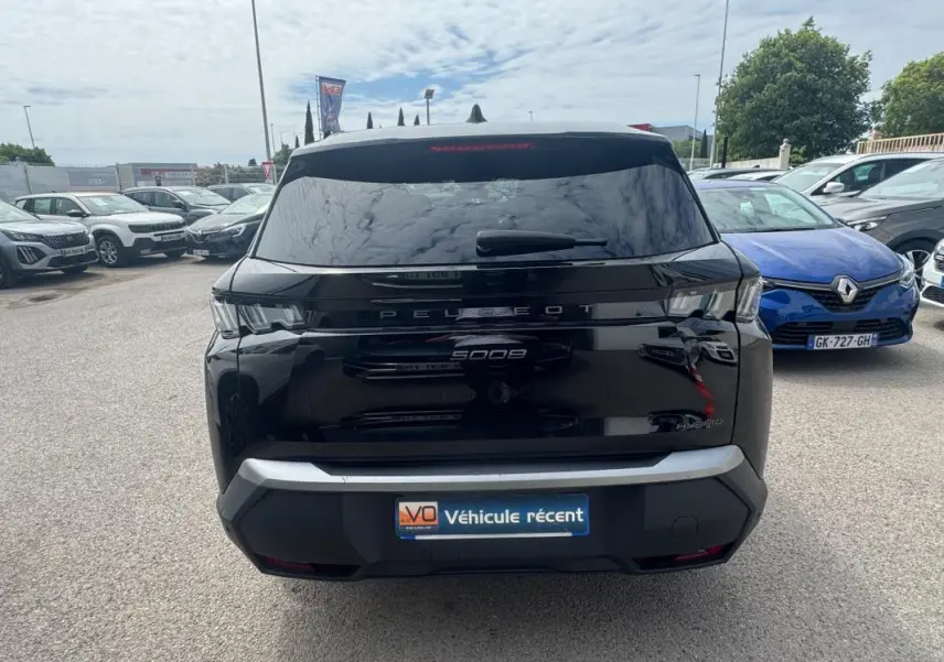 Vue arrière d’un Peugeot 5008 noir 2025 avec feux LED et badge Hybrid, stationné en extérieur.