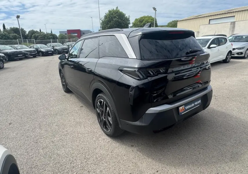 Peugeot 5008 Hybrid noir vue 3/4 arrière droit avec jantes alliage 19 pouces et barres de toit visibles.