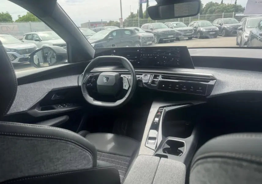 Vue intérieure du Peugeot 5008 Hybrid 145 ch Allure 2025, montrant le cockpit numérique et le volant compact.