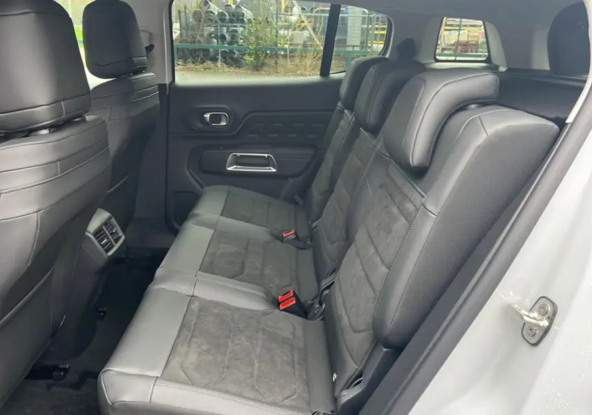 Vue latérale droite des trois sièges arrière individuels en cuir noir du Citroën C5 Aircross blanc okénite, intérieur spacieux.