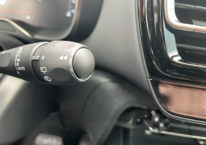 Gros plan sur la commande des essuie-glaces à gauche du volant dans l’habitacle du Citroën C5 Aircross blanc okénite.
