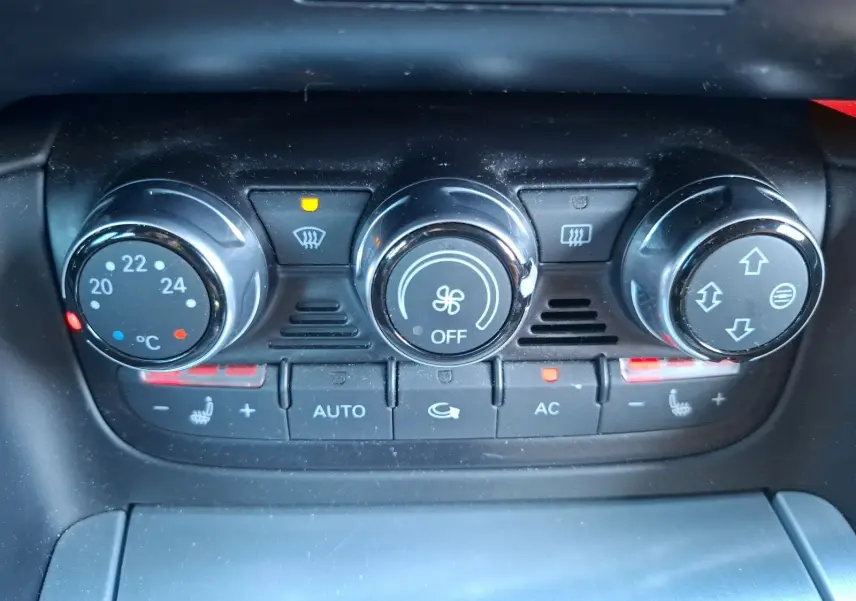 Gros plan sur la console de climatisation automatique de l'Audi TT 3.2 V6 Quattro avec réglages chauffants activés.