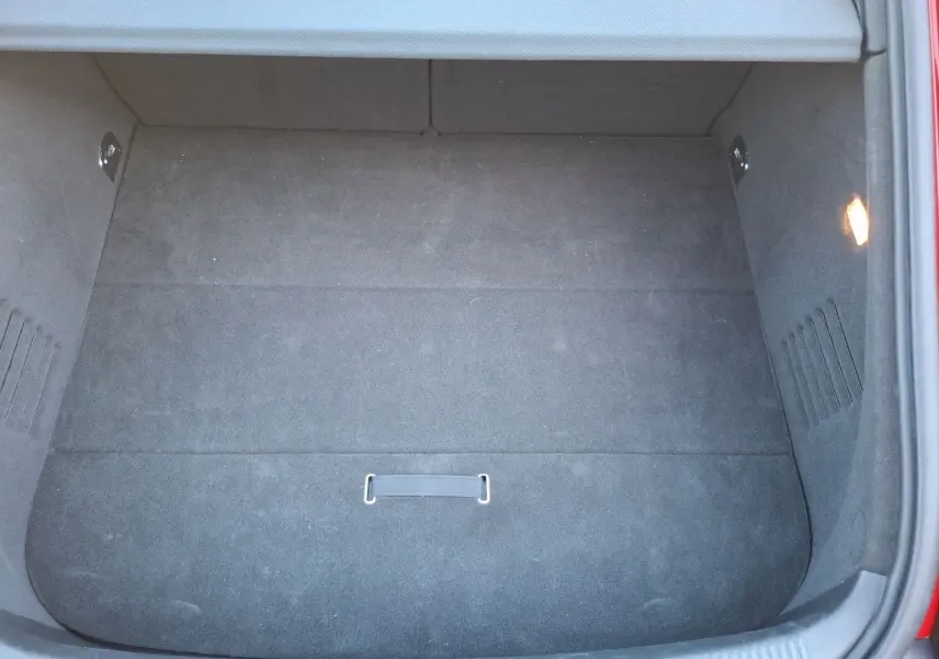 Coffre ouvert vu de dessus d’une Audi TT rouge 3.2 V6 Quattro de 2007, avec intérieur de coffre en tissu noir.