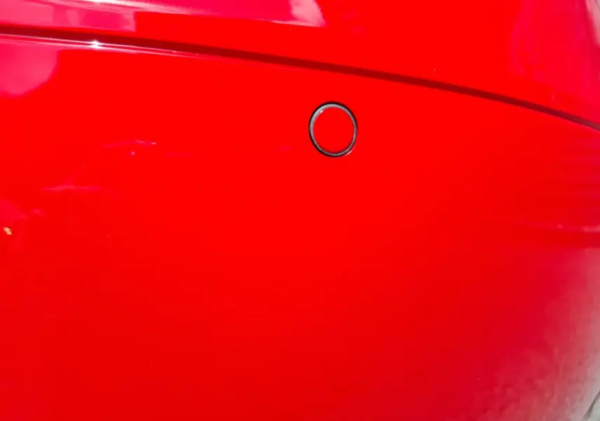 Gros plan sur le capteur de radar de stationnement arrière du pare-chocs rouge d’une Audi TT 3.2 V6 Quattro 2007.
