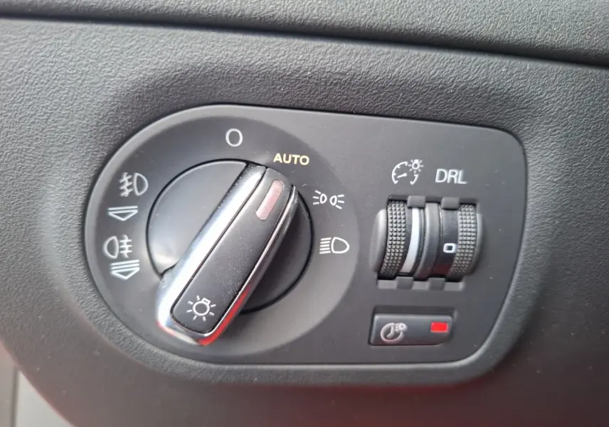 Gros plan sur le bouton de commande des phares et réglages lumineux de l’Audi TT 3.2 V6 Quattro rouge de 2007.