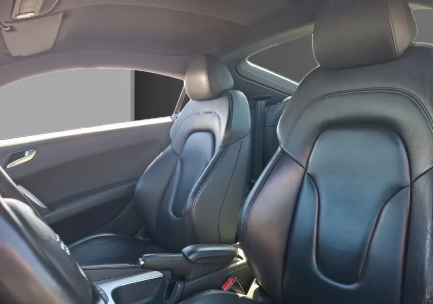 Vue intérieure des sièges avant en cuir noir de l'Audi TT 3.2 V6 Quattro de 2007, côté conducteur et passager.