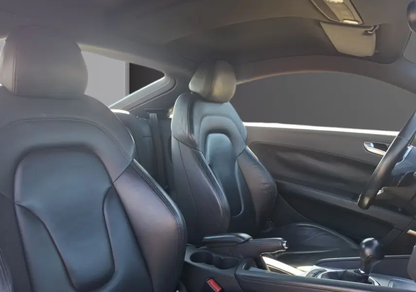 Vue intérieure côté droit de l’Audi TT 3.2 V6 Quattro 2007 avec sellerie cuir noire et volant partiellement visible.