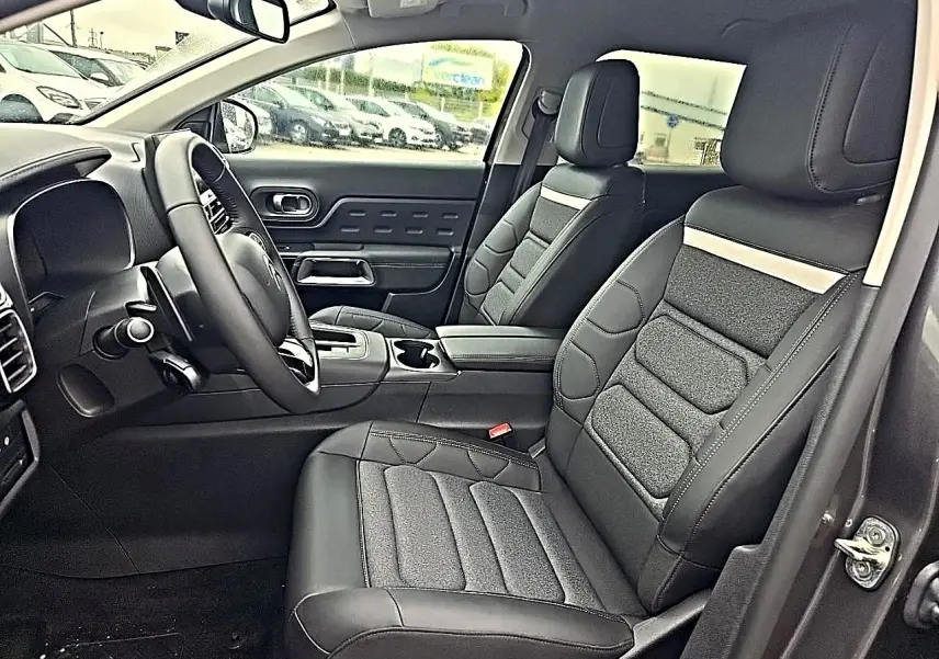Intérieur avant du Citroën C5 Aircross gris, vue côté conducteur avec sièges en cuir noir et tissu gris.
