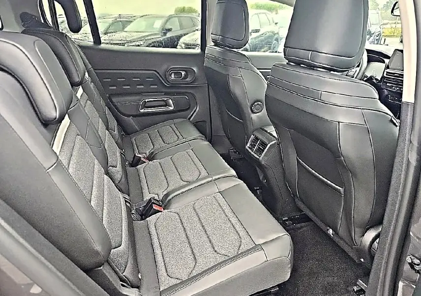 Vue intérieure côté gauche sur la deuxième rangée de sièges individuels en cuir noir du Citroën C5 Aircross 2025.