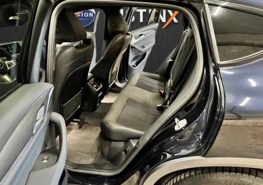 Vue côté droit arrière ouverte du BMW X4 XDrive 20d 2020 en Carbonschwarz, montrant l'intérieur gris noir et les sièges arrière.