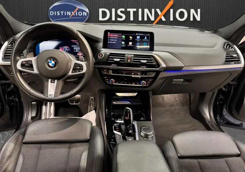 Intérieur BMW X4 XDrive 20d 2020 vu de face, tableau de bord moderne avec écran tactile et volant cuir noir M SPORT.