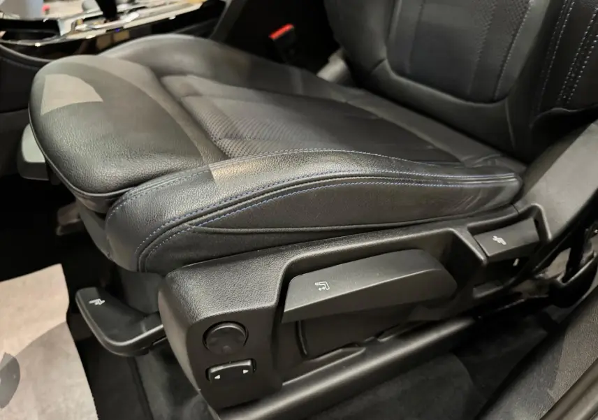 Gros plan sur le siège conducteur en cuir noir avec surpiqûres bleues du BMW X4 XDrive 20d 2020, côté gauche.