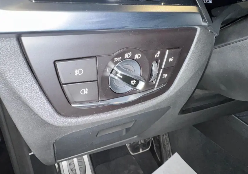 Gros plan sur le tableau de bord côté gauche du BMW X4 Carbonschwarz 2020, montrant la commande des phares et éclairages.