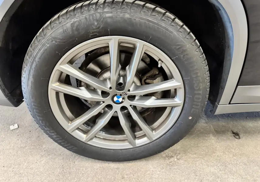 Gros plan sur la roue avant droite d'une BMW X4 XDrive 20d 2020 Carbonschwarz avec jante alliage 19 pouces.
