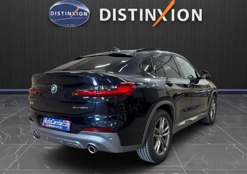 BMW X4 XDrive 20d 2020 en Carbonschwarz, vue 3/4 arrière droit, avec feux arrière LED et double sortie d’échappement.