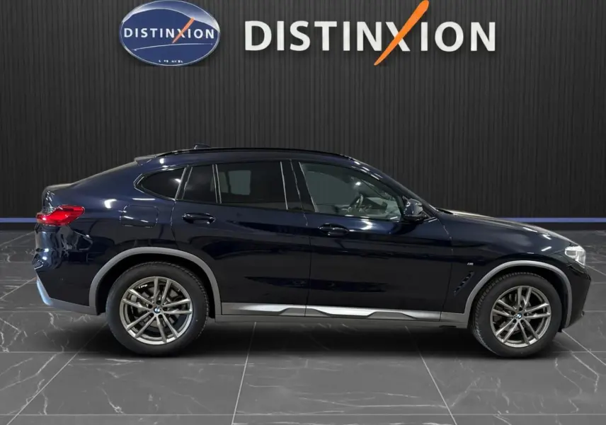 Profil côté gauche d'un BMW X4 XDrive 20d 2020 en Carbonschwarz, avec jantes alliage et lignes sportives M.