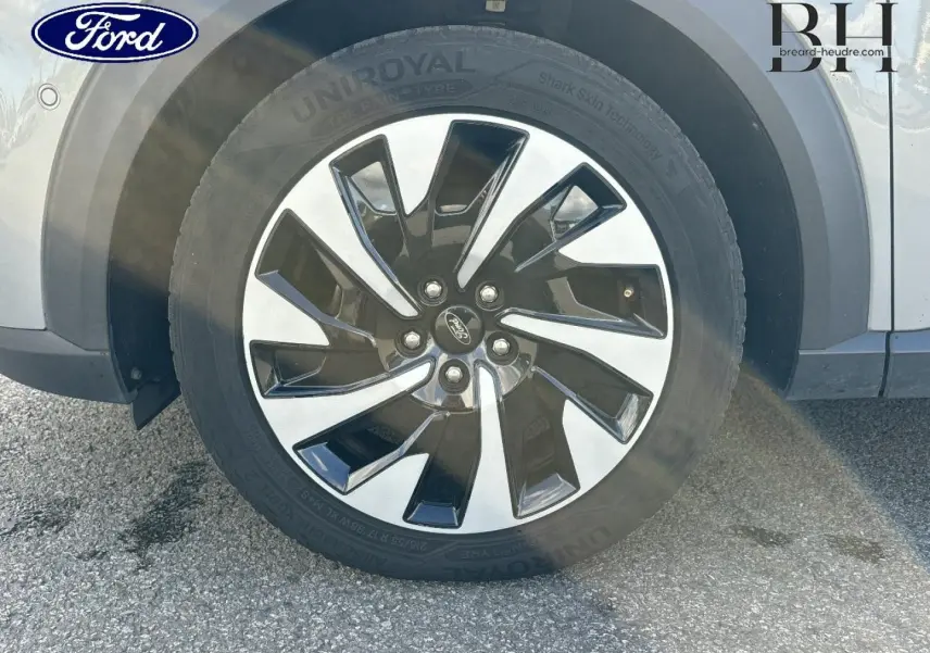 Gros plan sur la roue avant gauche avec jante alliage bicolore du Ford Puma gris Solar métallisé.