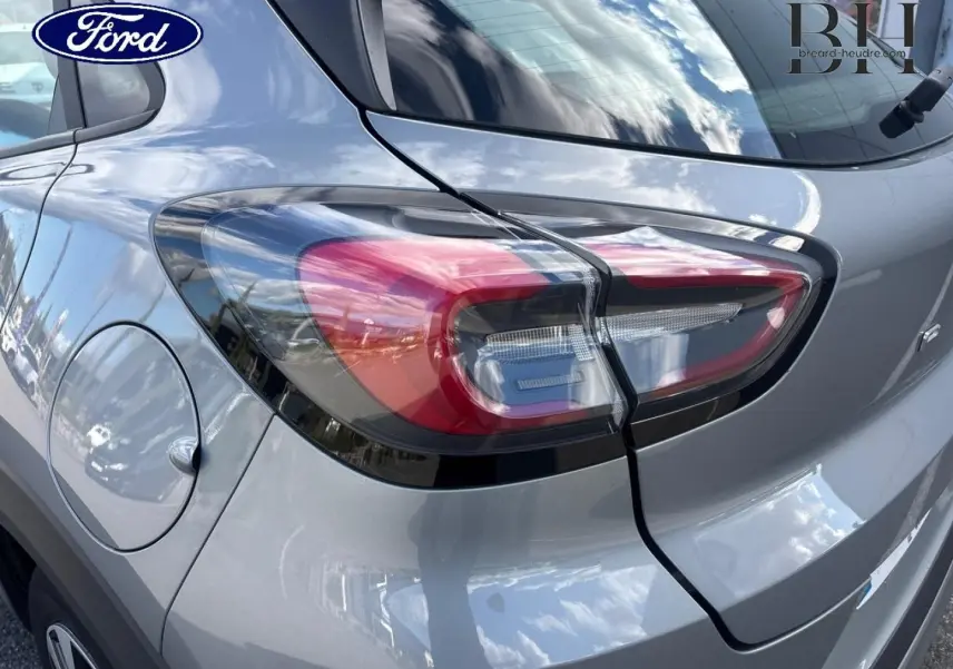 Gros plan sur le feu arrière droit d’un Ford Puma gris Solar métallisé, avec la trappe à carburant visible.