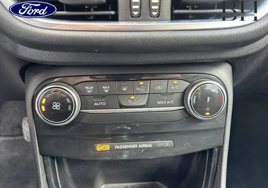 Gros plan sur la console centrale du Ford Puma 2023, montrant les commandes de climatisation et l'indicateur d'airbag passager.