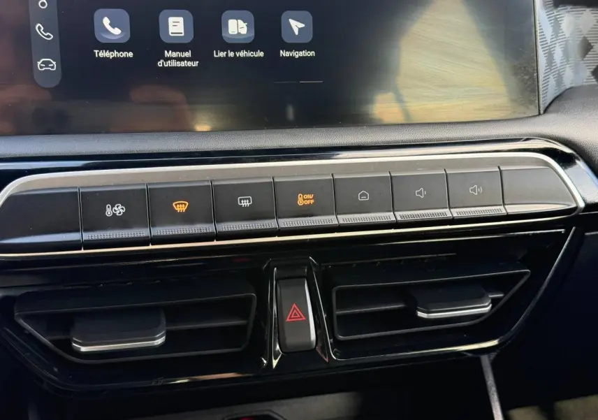 Vue rapprochée de la console centrale noire avec commandes climatisation et écran tactile du MG3 blanc 2025.
