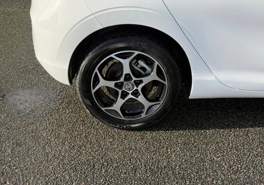 Gros plan sur la roue arrière droite d'une MG3 blanche avec jante alu à cinq branches distinctives.