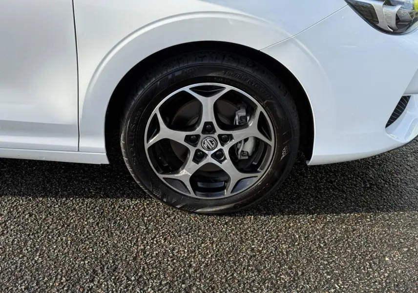 Gros plan sur la roue avant droite et une partie de la carrosserie blanche du MG3 1.5 Hybrid+ 195ch Luxury.