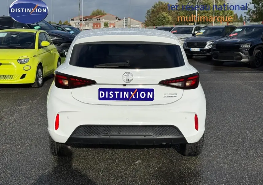 Vue arrière d'une MG3 blanche 2025 avec feux LED et vitres arrière surteintées sur parking extérieur.
