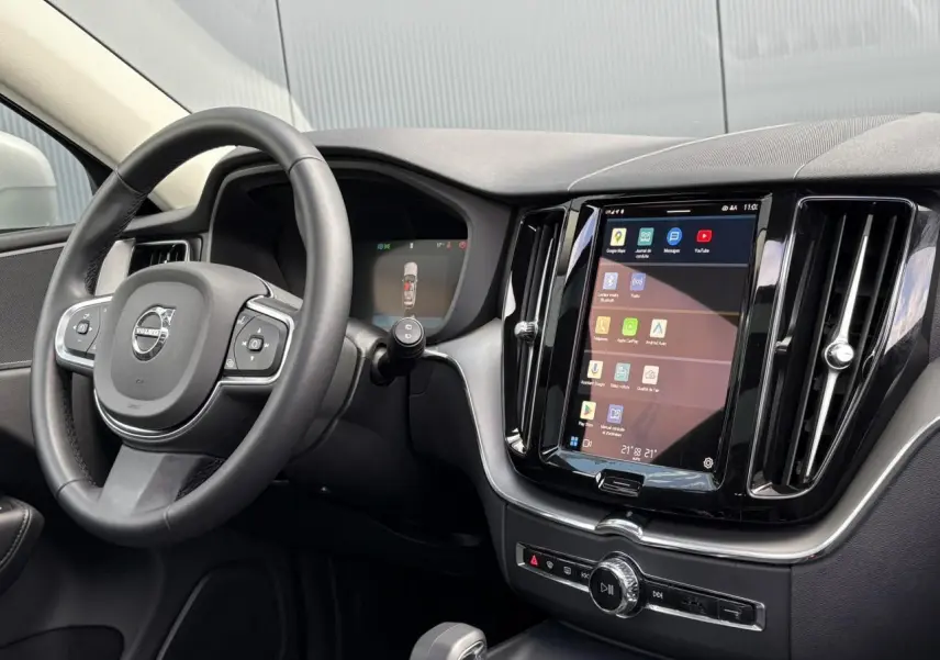 Intérieur du Volvo XC60 T6 AWD PHEV 2024, vue du tableau de bord et volant simili-cuir noir avec écran tactile central.