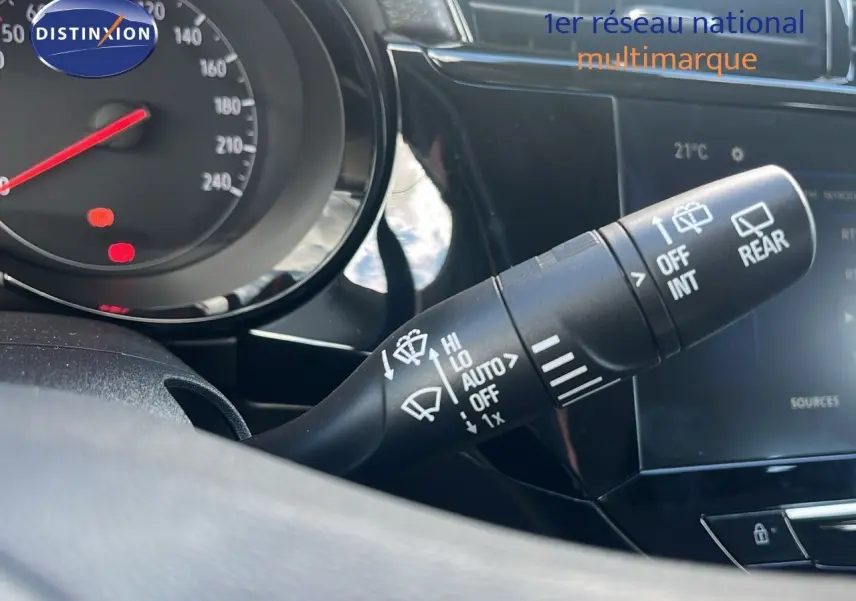 Gros plan sur la commande d’essuie-glace à gauche du volant dans l’habitacle d’une Opel Corsa gris kristal métal 2025.