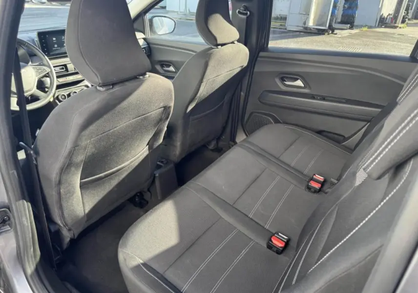 Vue intérieure côté droit sur la banquette arrière noire et les sièges avant du Dacia Jogger gris schiste 2025.