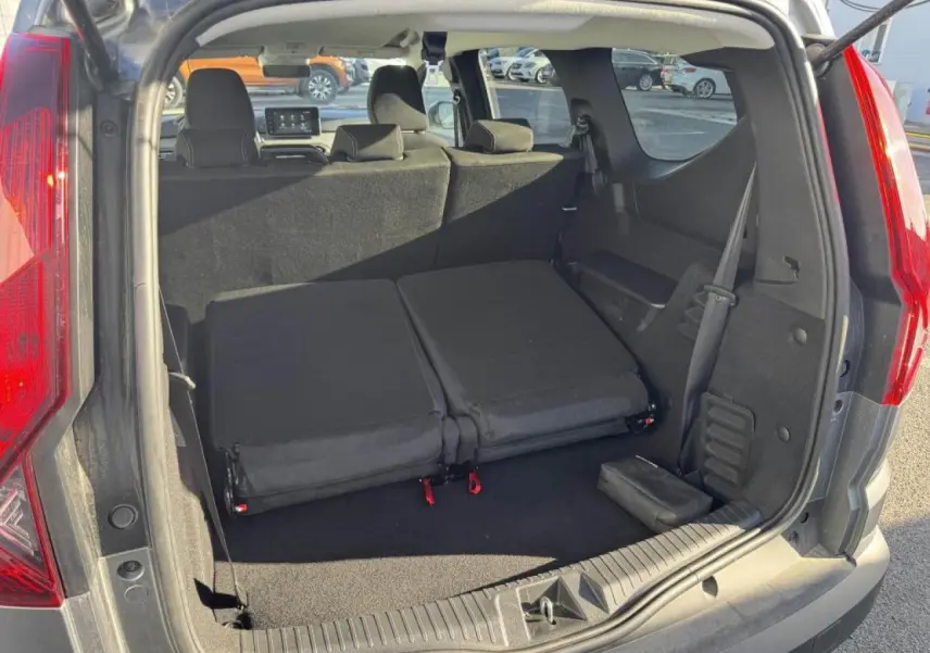 Vue arrière du coffre du Dacia Jogger gris schiste, sièges rabattus pour agrandir l'espace de chargement.