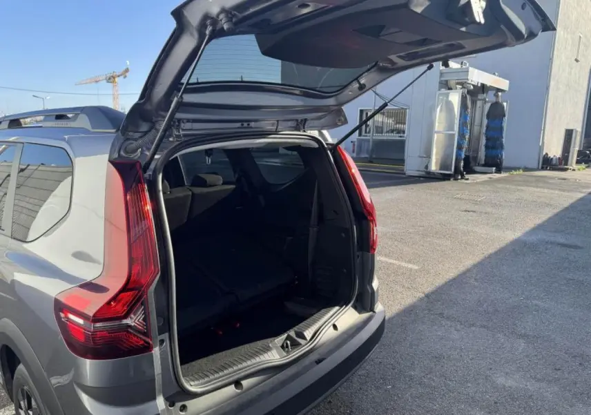Vue arrière ouverte en 3/4 droit d'un Dacia Jogger gris schiste métal avec feux arrière LED distinctifs.