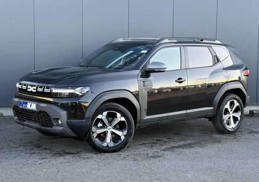 SUV Dacia Duster 2025 noir nacré en 3/4 avant droit, avec jantes alliage diamantées et barres de toit visibles.