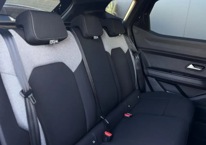 Vue latérale intérieure des sièges arrière bicolores gris et noir du Dacia Duster 2025 côté droit.