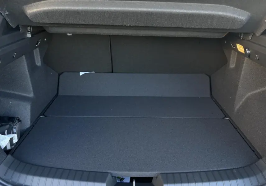 Coffre ouvert du Dacia Duster noir nacré, vue intérieure montrant le plancher plat et l’espace de chargement.