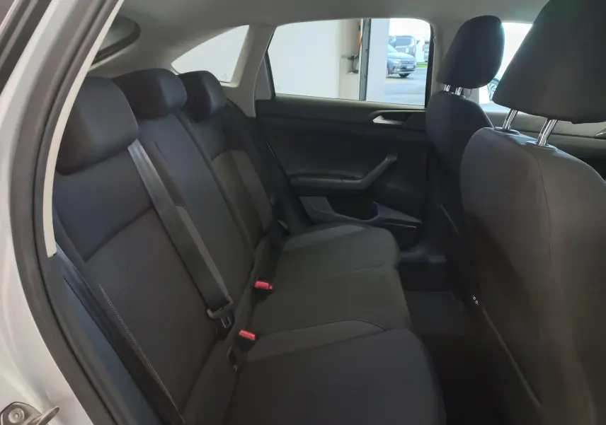 Vue intérieure côté gauche des sièges arrière noirs du Volkswagen Taigo 2025 avec portières ouvertes et ceintures visibles.