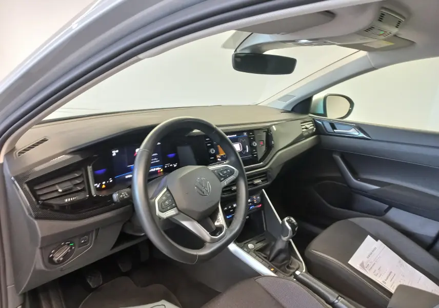 Vue intérieure côté conducteur du Volkswagen Taigo 2025, tableau de bord moderne avec volant multifonction et boîte manuelle.