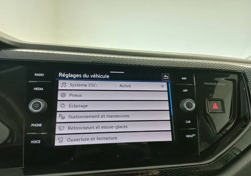 Écran tactile central du Volkswagen Taigo 2025 affichant les réglages du véhicule, entouré de boutons de commande noirs.