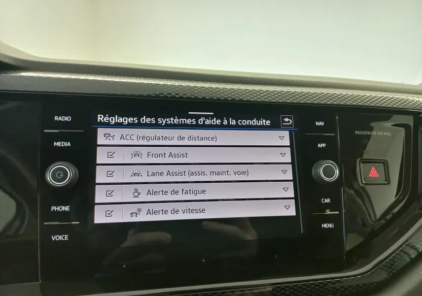 Vue intérieure du tableau de bord du Volkswagen Taigo 2025, écran tactile affichant les réglages d'aide à la conduite.