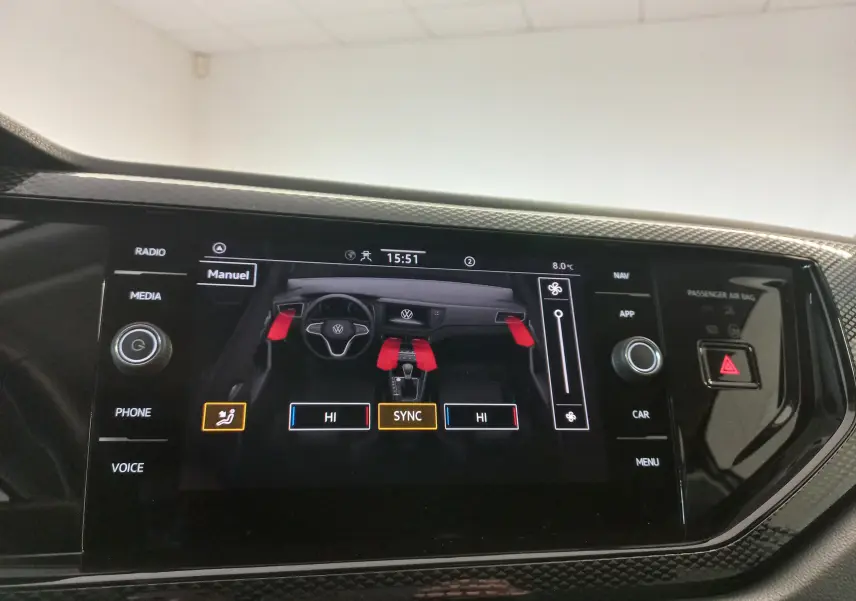 Écran tactile intérieur du Volkswagen Taigo 2025 affichant la climatisation bi-zone avec vue du tableau de bord en noir.