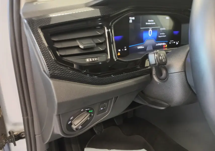 Vue intérieure côté gauche du tableau de bord du Volkswagen Taigo 2025, avec commandes d'éclairage et affichage numérique.