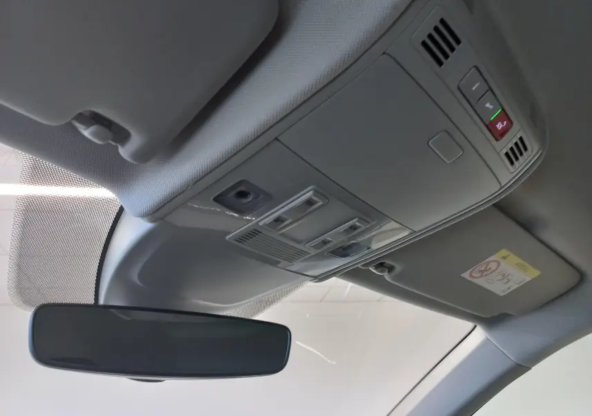 Vue intérieure du plafond avant avec rétroviseur et commandes d'éclairage dans un Volkswagen Taigo argent métallisé.