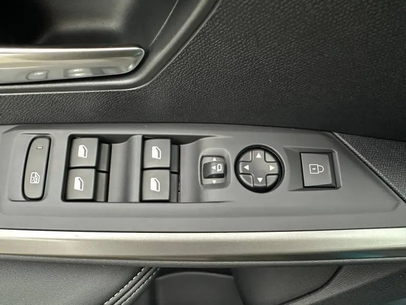 Gros plan sur les commandes des vitres et rétroviseurs côté conducteur d'un Peugeot 3008 bleu 2025.
