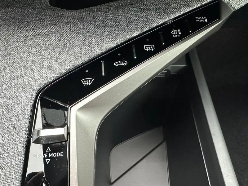 Détail de la console centrale du Peugeot 3008 bleu, montrant les commandes tactiles de climatisation et le sélecteur Drive Mode.