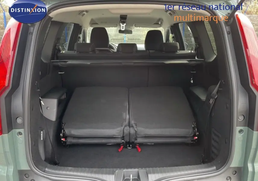 Vue arrière du coffre ouvert du Dacia Jogger kaki lichen avec sièges rabattus et espace de chargement visible.