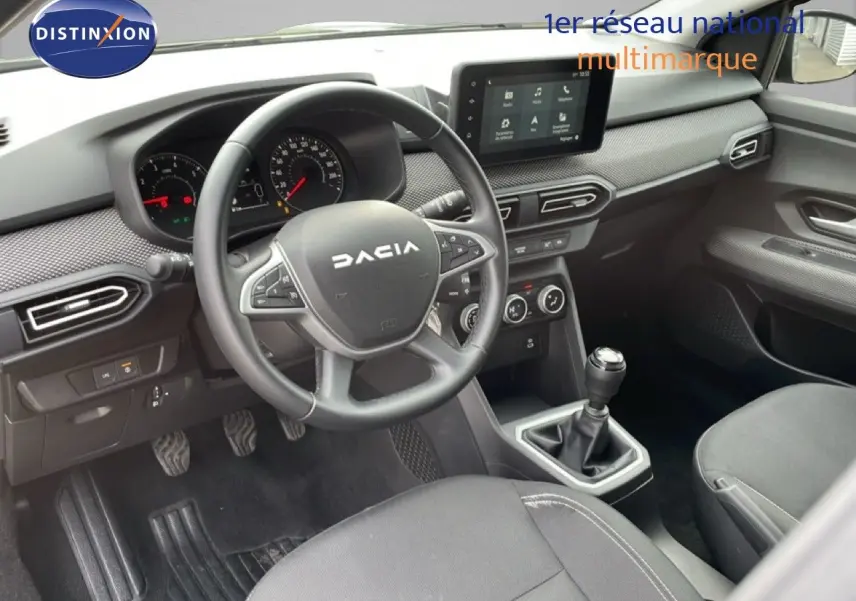 Vue intérieure côté conducteur du Dacia Jogger 2025, montrant le volant, tableau de bord et levier de vitesses manuelle.