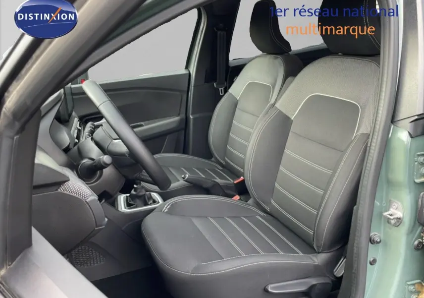 Vue intérieure côté conducteur du Dacia Jogger 2025 en kaki lichen, montrant les sièges avant en tissu noir et gris.