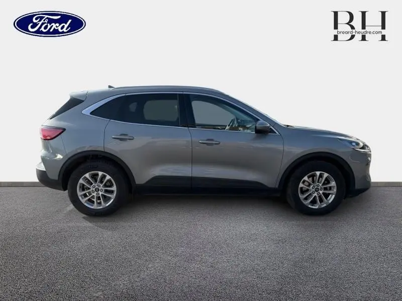 Profil droit du Ford Kuga 2.0 EcoBlue 150ch mHEV Titanium gris Solar métallisé avec jantes alliage et barres de toit.