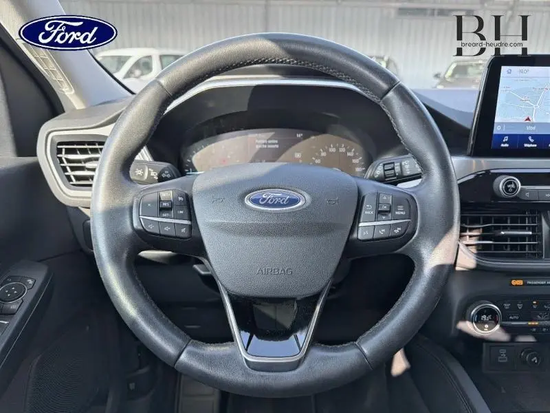 Vue intérieure centrée sur le volant cuir multifonction du Ford Kuga 2.0 EcoBlue 2020 avec écran tactile et tableau de bord.